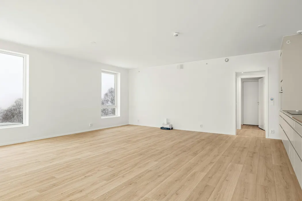 After (stock photo): a finished room with smooth white walls and new wood flooring
